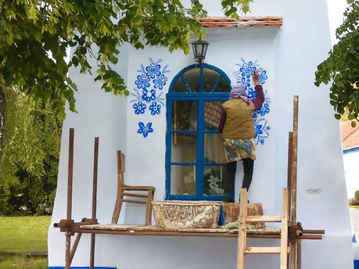 「藍色花朵」開滿整個純白小鎮！　90歲奶奶每天手繪「浪漫圖騰」遊客慕名朝聖