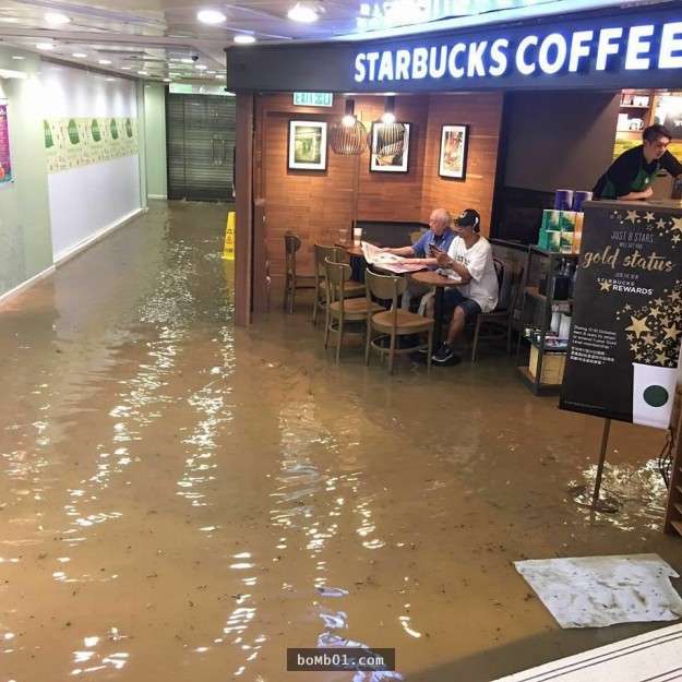 強者爺爺在颱風淹水時仍「淡定坐在星巴克喝咖啡看報紙」，這超有意境的畫面已經成為網友最愛的PS修圖素材了！